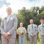 A group of groomsmen standing in front of a wedding ceremony.