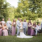 A group of bridesmaids and groomsmen posing for a wedding portrait.