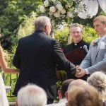 A couple exchanges vows during their outdoor wedding ceremony.