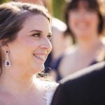 A couple smiles at each other during their wedding ceremony.