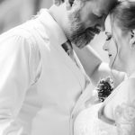 A black and white photo capturing the wedding reception as the bride and groom share their first dance.