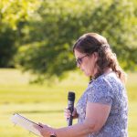 A woman is speaking at a wedding ceremony.