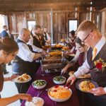 A group serving food at a wedding reception.