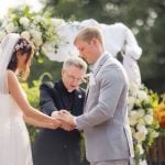 At a wedding ceremony, a bride and groom exchange rings.