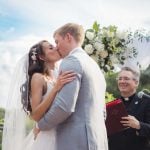 A couple shares a kiss at their wedding ceremony.