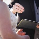 A man is performing a wedding ceremony for a bride.