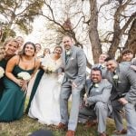 A group of bridesmaids and groomsmen posing for a wedding portrait.