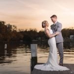 A wedding portrait on a dock at sunset.