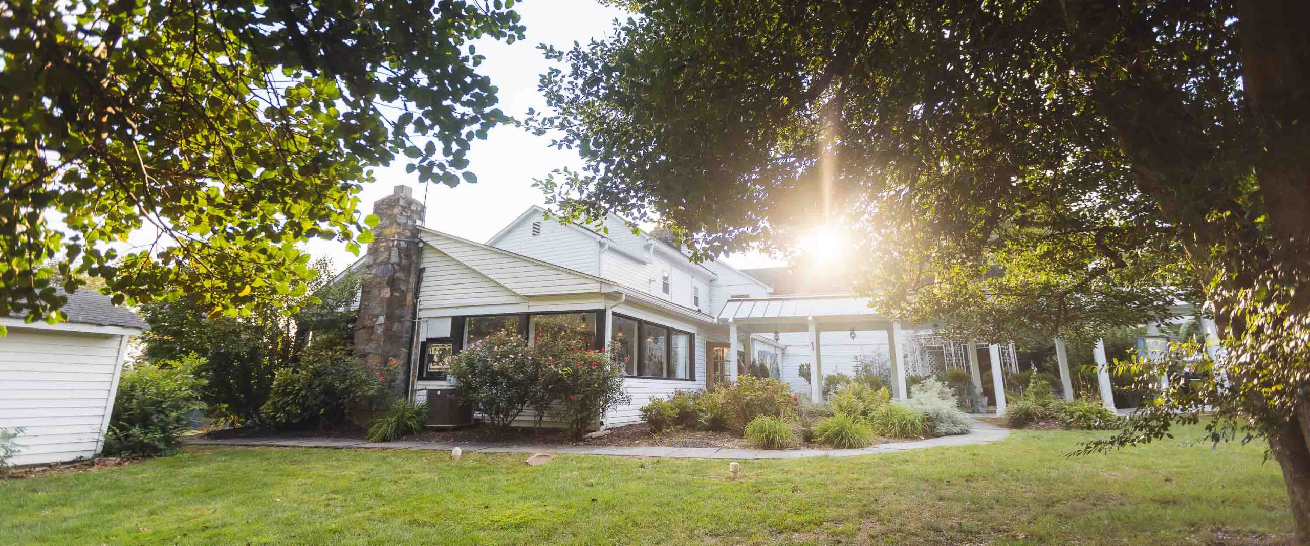 A white house with trees in the background in Alexandria, Virginia.