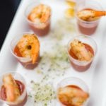 A white plate with shrimp and sauce on it, showcasing intricate details.