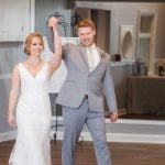 A bride and groom walking down the aisle at their wedding reception.