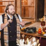 A man speaking into a microphone at a wedding reception.