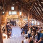 A barn wedding ceremony with a large crowd.