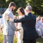 A couple exchanging their vows at an outdoor wedding ceremony.