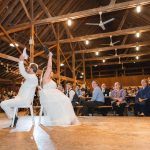 A bride and groom dancing at their wedding reception in a barn.