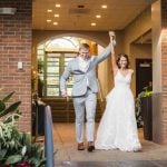 A bride and groom are exiting a wedding reception.