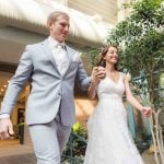 A bride and groom walking through a wedding reception.