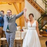 A couple is walking down the aisle at their wedding reception.