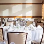 Details: A room with detailed tables and chairs set up for a wedding reception.