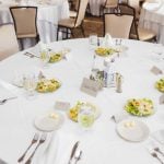 A detailed wedding table setting with plates and silverware.