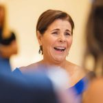 A woman laughing at a wedding reception.