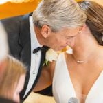 A couple sharing a kiss at their wedding reception.