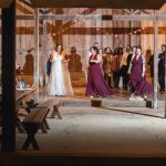 A group of bridesmaids standing in a barn at night during a wedding reception.