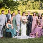 A wedding party posing for a portrait in a field.