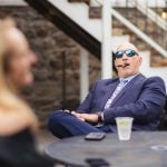 A man in a suit attending a wedding reception.