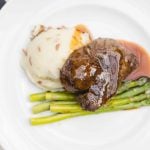 Wedding menu details featuring a plate with steak, asparagus, and mashed potatoes.