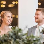 A couple smiling at each other during their wedding reception.