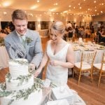 A bride and groom cutting their wedding cake at the reception.