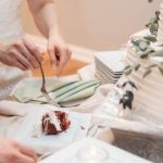 A couple cutting into their wedding cake at their reception.