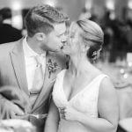 A bride and groom sharing a kiss at their wedding reception.