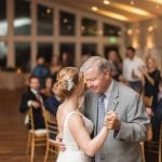 A bride and her father dance at their wedding reception.