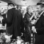 Black and white photo of groom and groomsmen at a wedding reception.