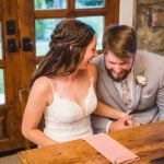 A couple sitting at a table during their wedding reception.