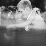 A black and white photo of a bride and groom hugging during their wedding.