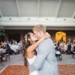 A couple kissing on the dance floor at their wedding reception.