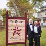 A wedding portrait taken in front of the barns sign.