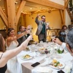 A wedding reception featuring a toasting bride and groom.