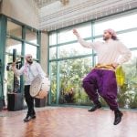 Two men are dancing at a wedding reception.