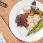 A plate with steak, asparagus, and mashed potatoes for a wedding feast.