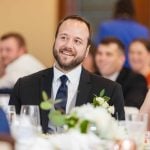 A couple smiling at each other during a wedding reception.