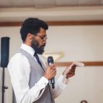 A man speaking at a wedding reception.