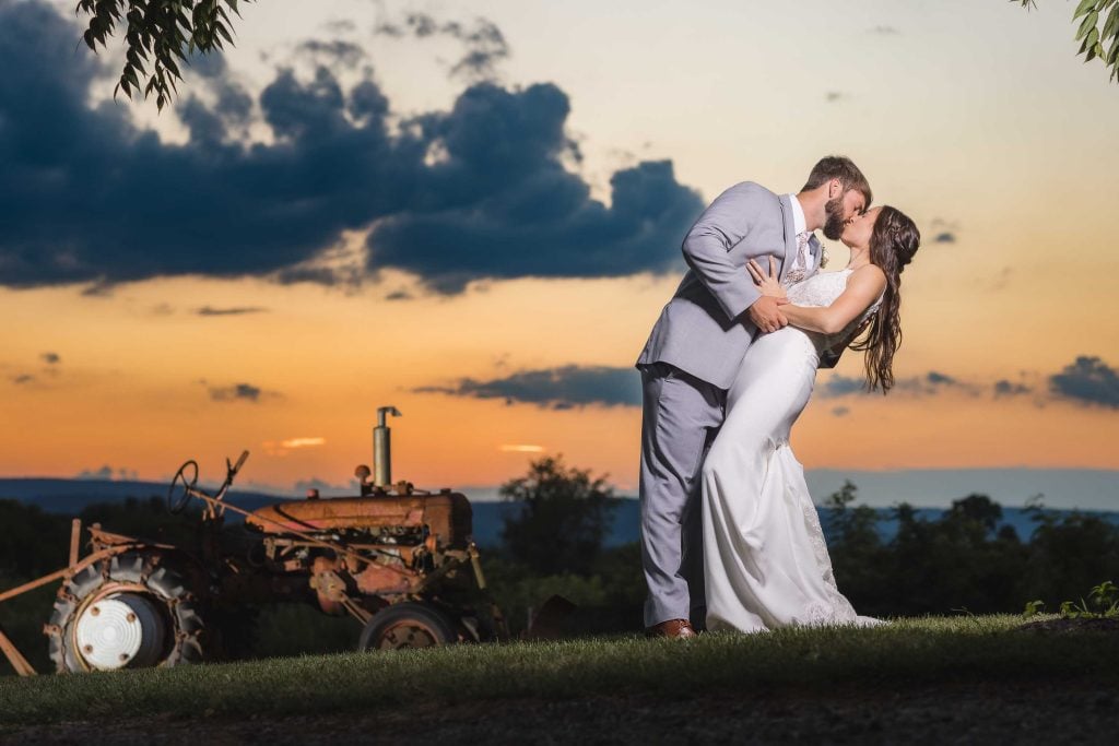 A bride and groom share a romantic kiss during their wedding portrait.