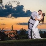 A bride and groom share a romantic kiss during their wedding portrait.