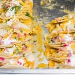 A tray of wedding tacos with sour cream and onions.