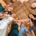 Wedding party poses for group photo at reception.