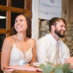 A bride and groom share a lighthearted moment during their wedding reception.